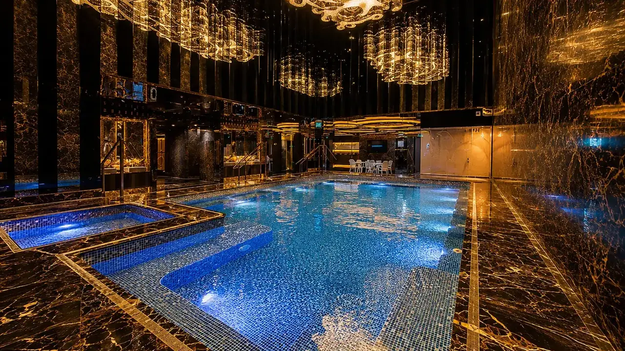 澳门桑拿尊贵水疗的室内按摩浴池——水晶吊灯下的蓝色池水与大理石池畔。